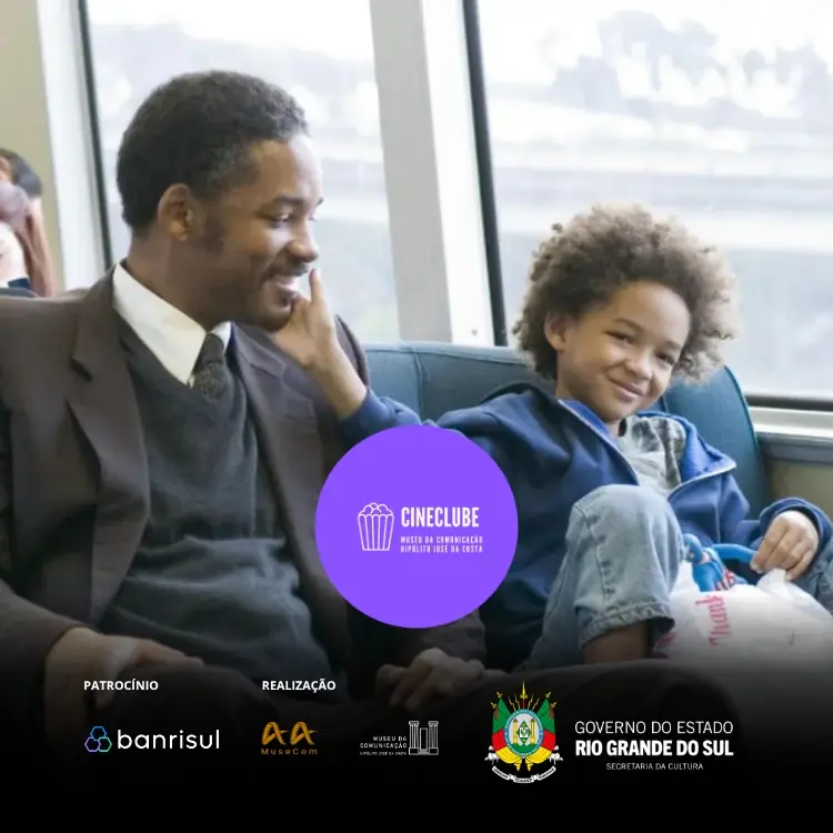 Imagem mostra um homem negro e uma criança negra sentados, lado a lado, em um banco de transporte público. O homem sorri enquanto a criança toca carinhosamente seu rosto. Ao fundo, há grandes janelas. No canto superior direito, há um adesivo roxo com a marca "CINECLUBE" em branco. Na parte inferior, uma faixa escura exibe, da esquerda para a direita, os logos "PATROCÍNIO: banrisul", "REALIZAÇÃO: AA MuseCom", "MuseCom" e "GOVERNO DO ESTADO: RIO GRANDE DO SUL, SECRETARIA DA CULTURA".